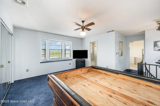 a room with pool table flat screen tv and windows
