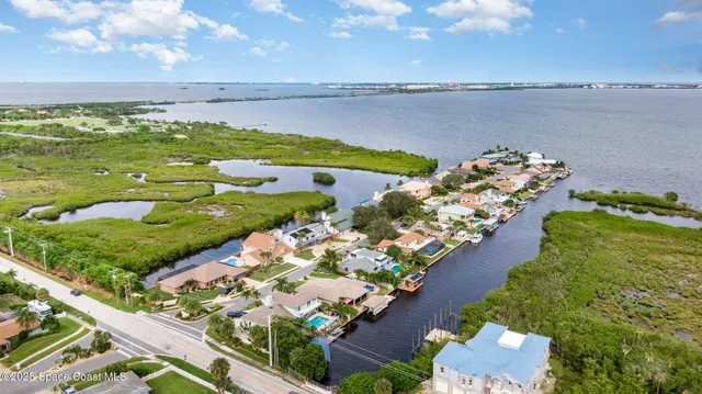 an aerial view of a house with a garden and lake view