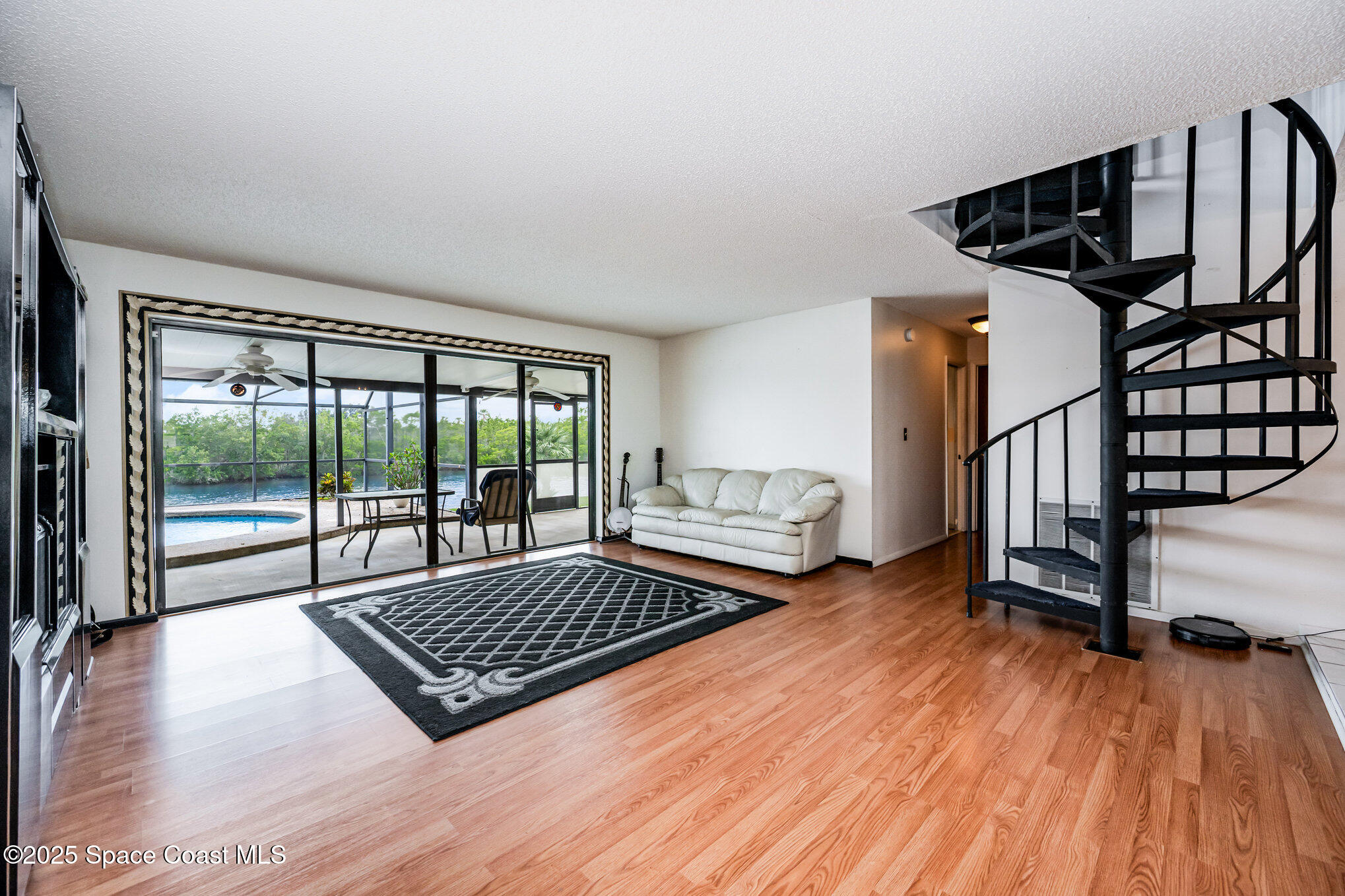 1635 Sandpiper Street Merritt Island, FL 32952 - Photo 10 of 31 a living room with couch floor to ceiling window and a wooden floor