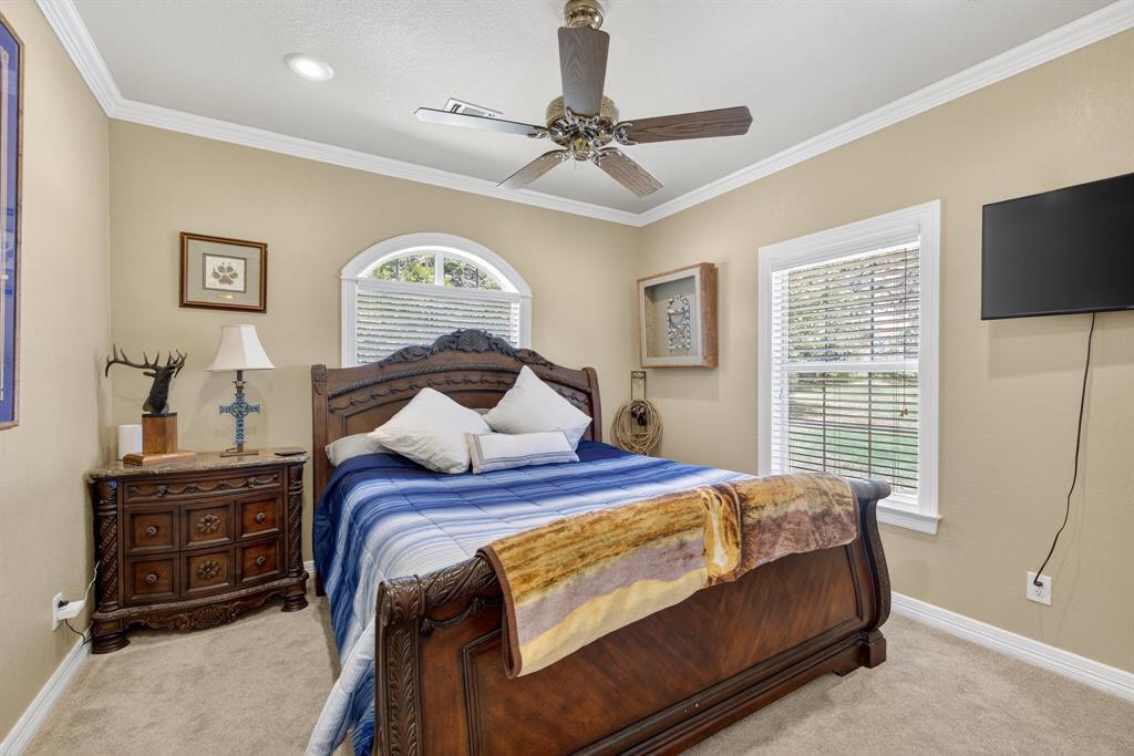 482 Center Hill Road Gainesville, TX 76240 - Photo 15 of 38 a bedroom with a bed and a flat tv screen on dresser