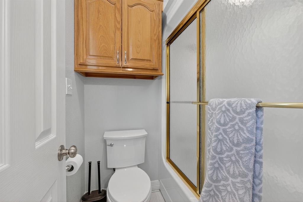 482 Center Hill Road Gainesville, TX 76240 - Photo 17 of 38 a bathroom with a toilet and a shower curtain
