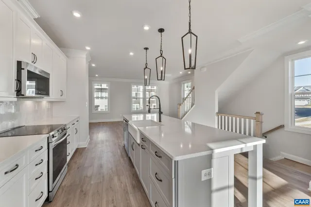 a kitchen with kitchen island a sink stove and wooden floor