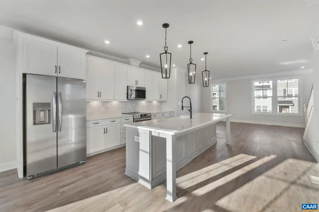 a kitchen with white cabinets and stainless steel appliances
