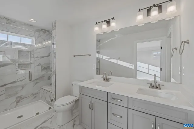 a bathroom with a sink a toilet and shower