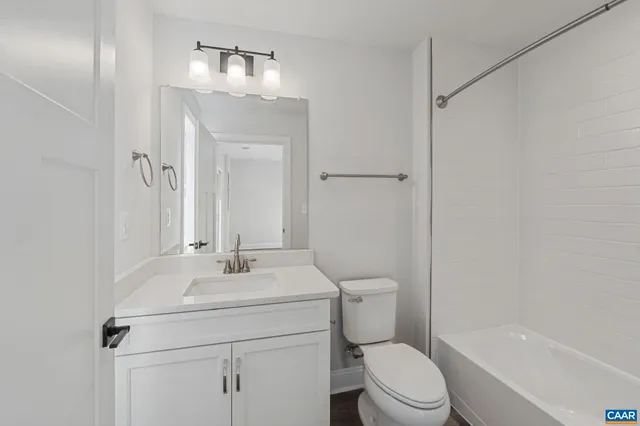a bathroom with a sink toilet vanity and shower