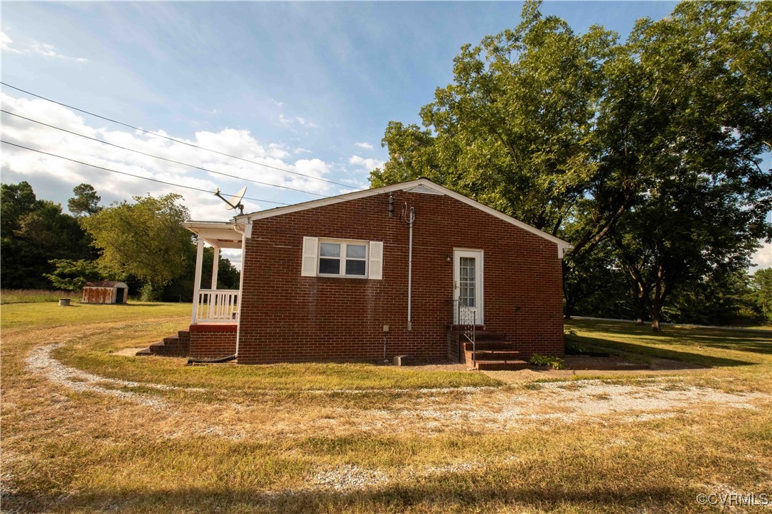 View of property exterior featuring a lawn and a s