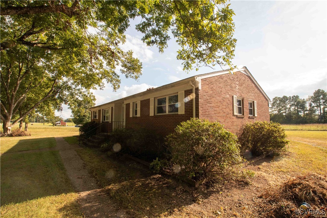 View of side of home with a yard