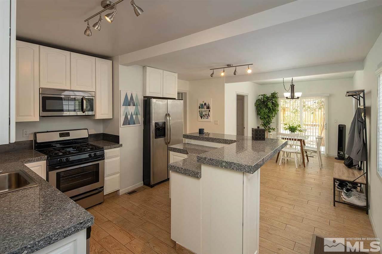 618 Thoma Street Reno, NV 89502 - Photo 7 of 31 a kitchen with stainless steel appliances granite countertop a stove refrigerator and a microwave