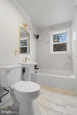 a bathroom with a toilet a sink and bathtub
