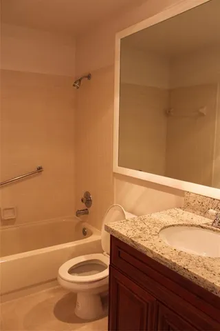 a bathroom with a granite countertop bathtub toilet and sink