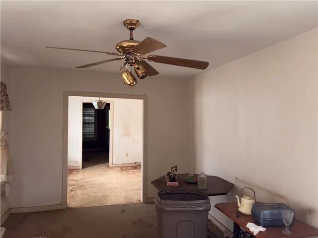 a room with a chandelier fan and a window