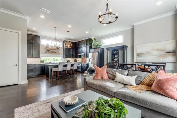a living room with furniture kitchen and a chandelier