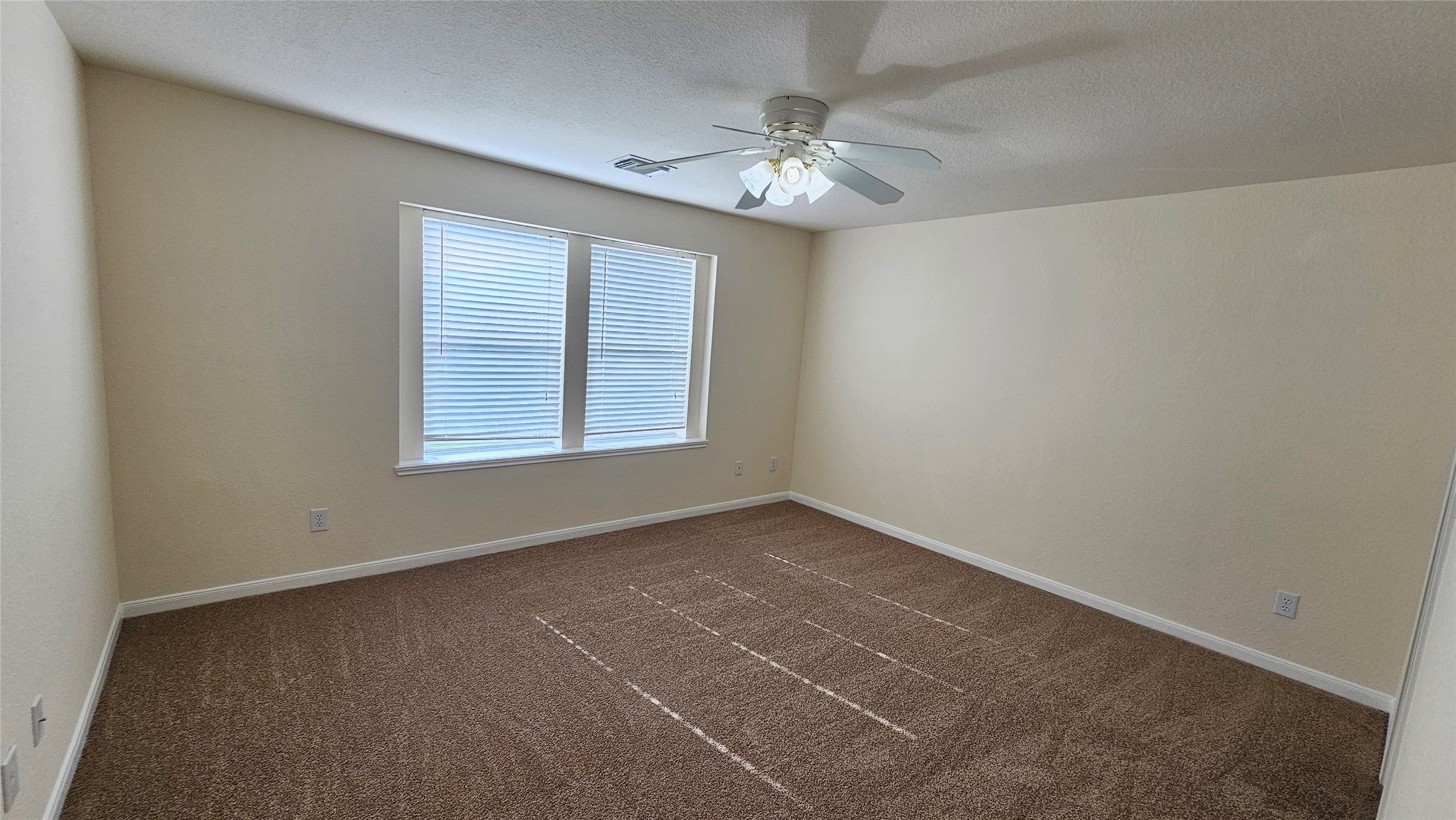 7918 Barnes Ridge Lane Houston, TX 77072 - Photo 23 of 34 This photo shows a bright, carpeted room with neutral walls and a ceiling fan. It has a large window with blinds, providing natural light. Ideal for a bedroom or home office.