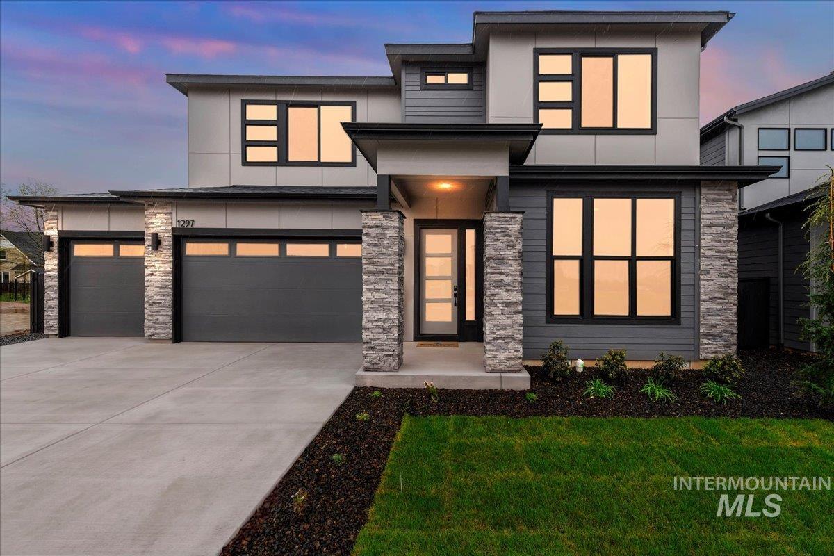 1297 West Malbar Street Meridian, ID 83646 - Photo 1 of 34 Modern facade featuring stacked stone accents, a multi-pane glass entry door, and a two-car garage