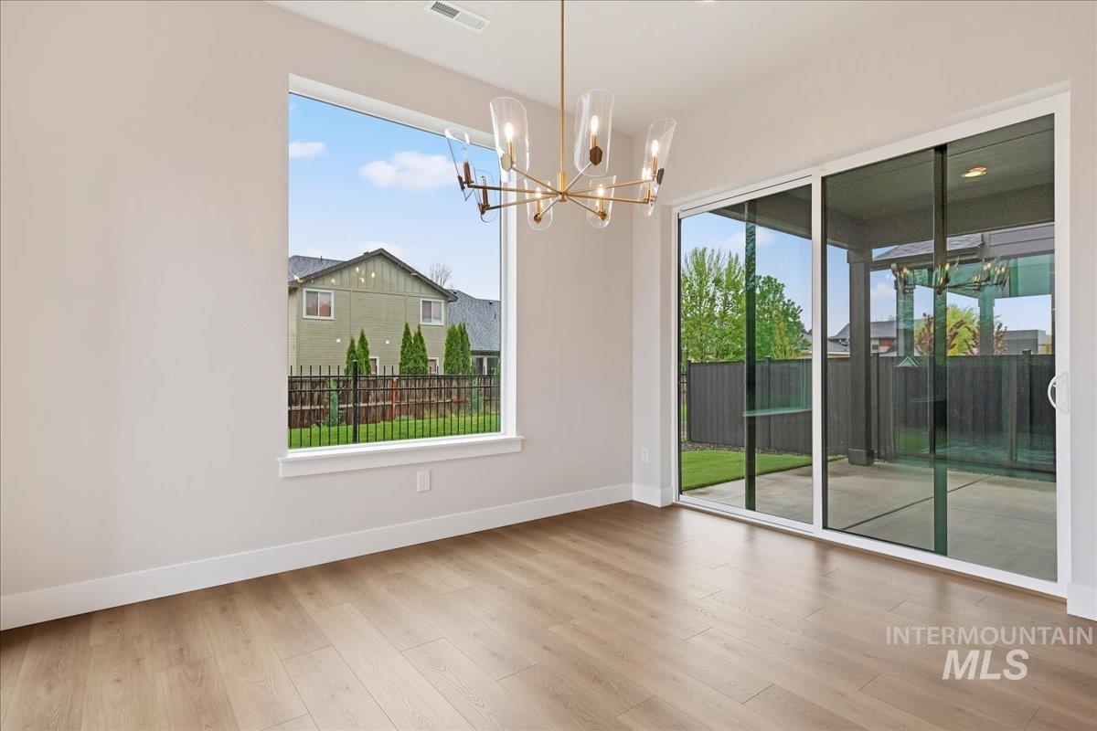 1297 West Malbar Street Meridian, ID 83646 - Photo 15 of 34 Room featuring wood-finish flooring, a large picture window, and expansive sliding glass doors