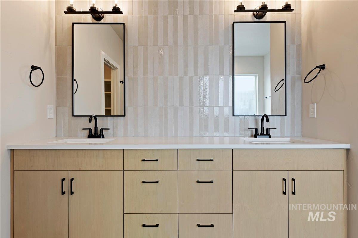 1297 West Malbar Street Meridian, ID 83646 - Photo 23 of 34 Dual vanity with light wood-finish cabinetry, white countertop, and rectangular undermount sinks
