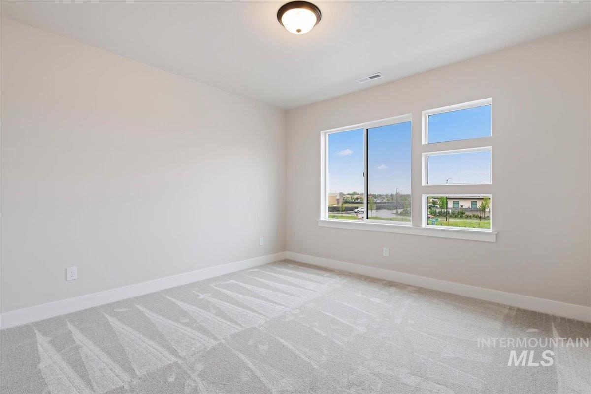 1297 West Malbar Street Meridian, ID 83646 - Photo 25 of 34 Room featuring light gray walls, white baseboards, and a neutral patterned carpet
