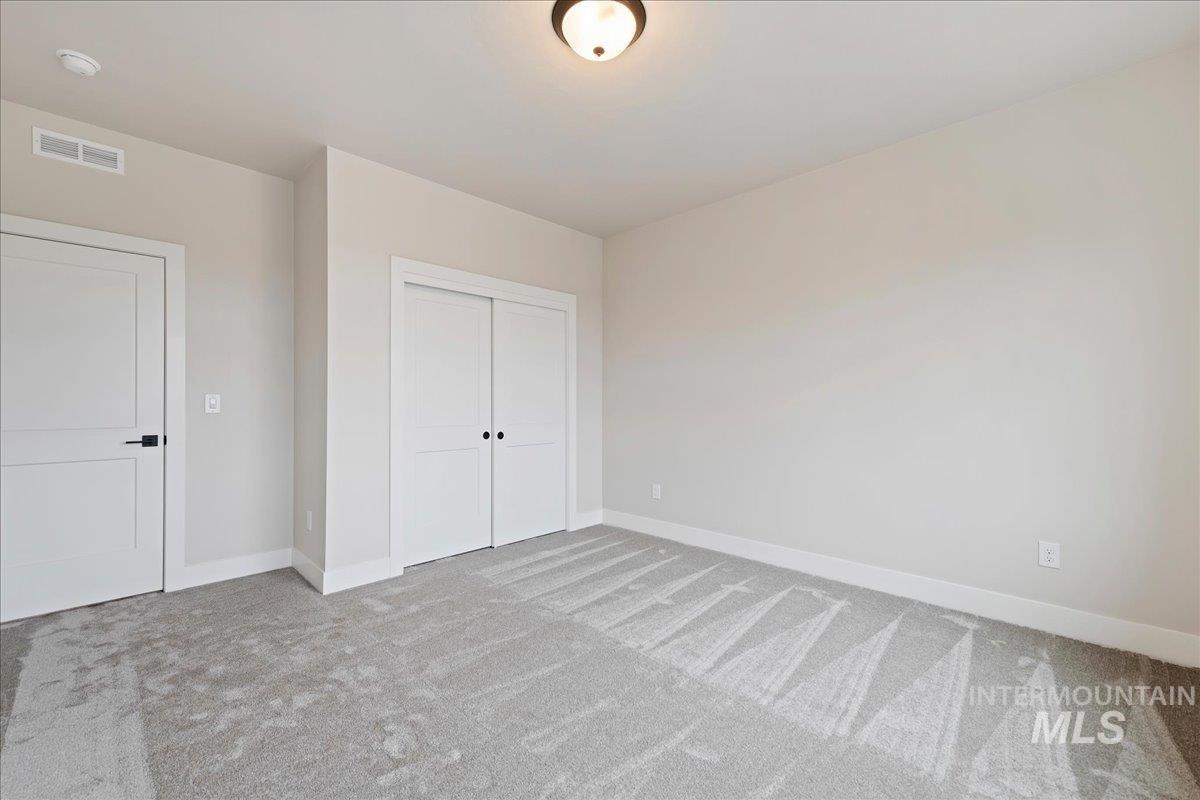 1297 West Malbar Street Meridian, ID 83646 - Photo 26 of 34 Neutral-toned room featuring light gray carpeting, white trim, and a white interior door with black hardware