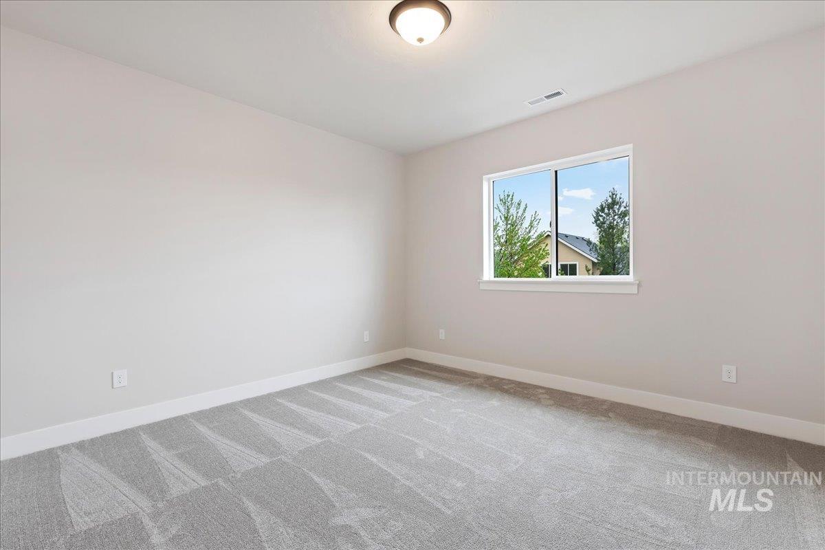 1297 West Malbar Street Meridian, ID 83646 - Photo 27 of 34 Bright room featuring light grey walls, grey patterned carpet, white baseboards, and a single window with white trim