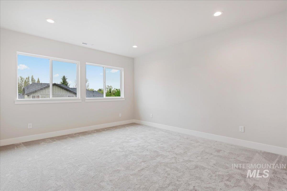 1297 West Malbar Street Meridian, ID 83646 - Photo 28 of 34 Spacious room featuring light gray carpeting, neutral wall finishes, and a series of three large windows providing abundant illumination