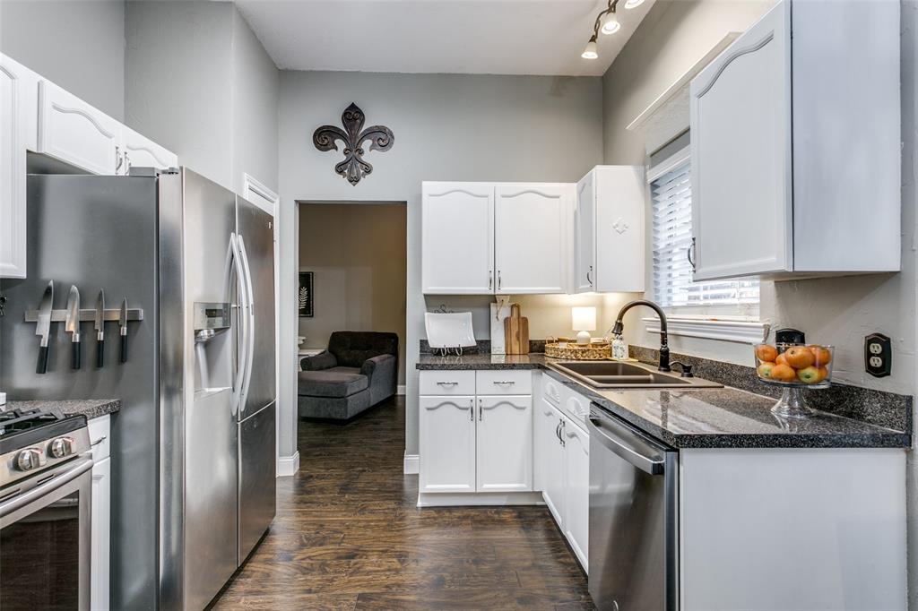 2133 Rim Rock Drive Keller, TX 76248 - Photo 19 of 37 Kitchen with dark wood-style floors, appliances with stainless steel finishes, dark stone counters, and white cabinetry