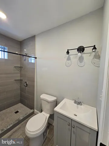 a bathroom with a toilet sink vanity and shower