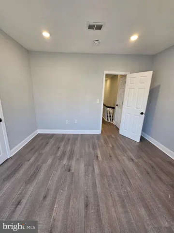 an empty room with wooden floor and closet