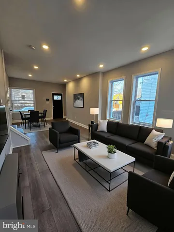 a living room with furniture kitchen view and a window