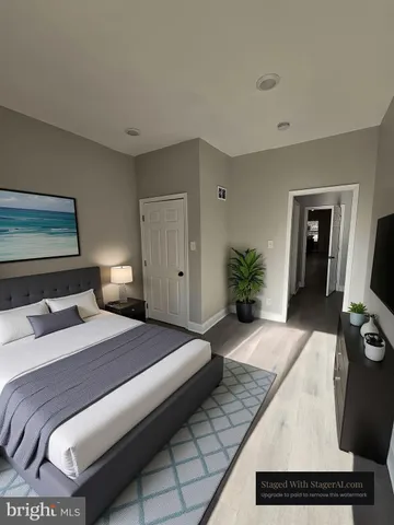 a bedroom with a bed and a potted plant on dresser