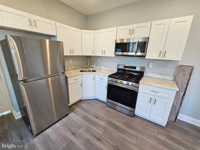 a kitchen with white cabinets and stainless steel appliances