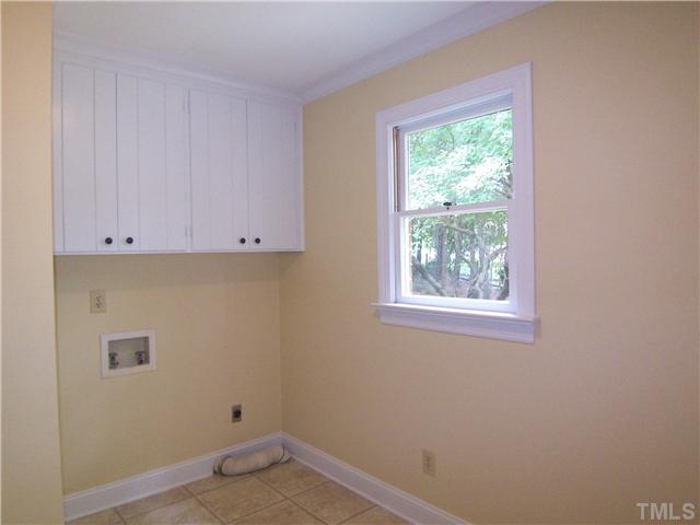 6905 Brook Ridge Court Raleigh, NC 27615 - Photo 12 of 25 Nearby is the pantry; lg Laundry/Mud Rm w/laminate tile flr, cabinets and room for a freezer; full Bath; attached oversized 2-car Garage; back stairs to BonusRm.