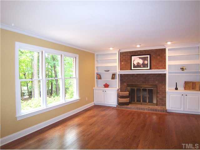 6905 Brook Ridge Court Raleigh, NC 27615 - Photo 7 of 25 FamilyRm w/brick gas log FP flanked by cabinetry, hrdwd flr & door to huge Deck is completely open to the fabulous eat-in KIT.