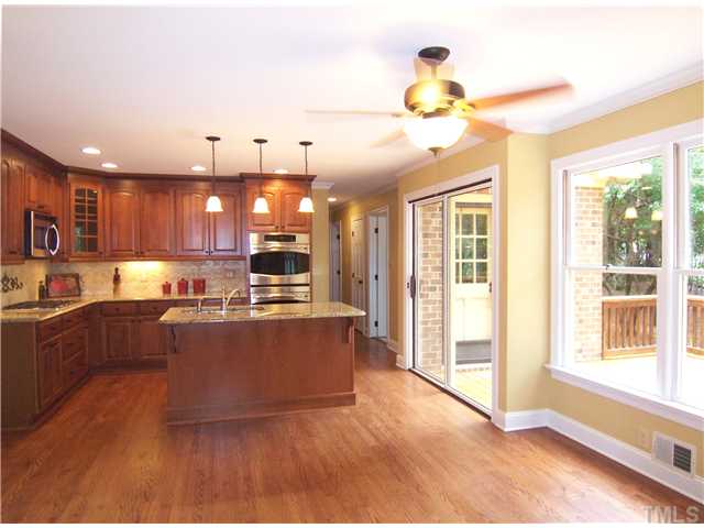 6905 Brook Ridge Court Raleigh, NC 27615 - Photo 9 of 25 RENOVATED eat-in KIT w/granite ctrs & island w/sink/DW, 42" cherry cabinets, stone tile backsplash, SS dbl wall ovens & gas cooktop, hardwd flr, pendant lights, sunny B'fast area w/CF & box bay windows!