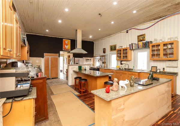 a large kitchen with stainless steel appliances kitchen island granite countertop a sink and cabinets