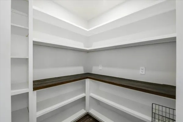 an empty room with wooden floor chandelier and windows