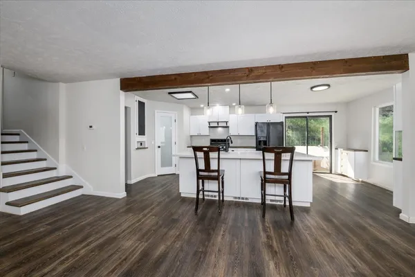 a kitchen with a table chairs a sink dishwasher stove and cabinets with wooden floor