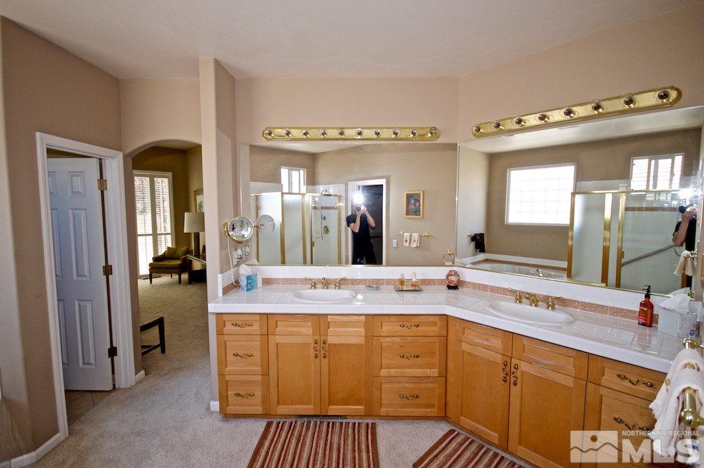 1820 Hunter Creek Road Reno, NV 89519 - Photo 11 of 22 a bathroom with a granite countertop sink a mirror and a bathtub