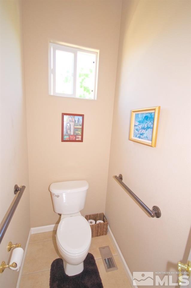1820 Hunter Creek Road Reno, NV 89519 - Photo 12 of 22 a white toilet sitting next to a bathroom sink and a mirror