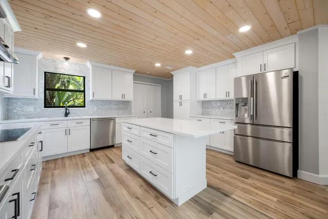 a kitchen with stainless steel appliances a refrigerator sink and cabinets