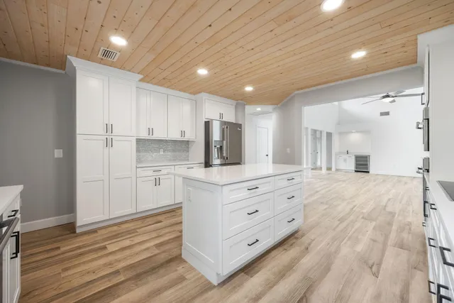 a kitchen with stainless steel appliances kitchen island granite countertop a refrigerator and a stove