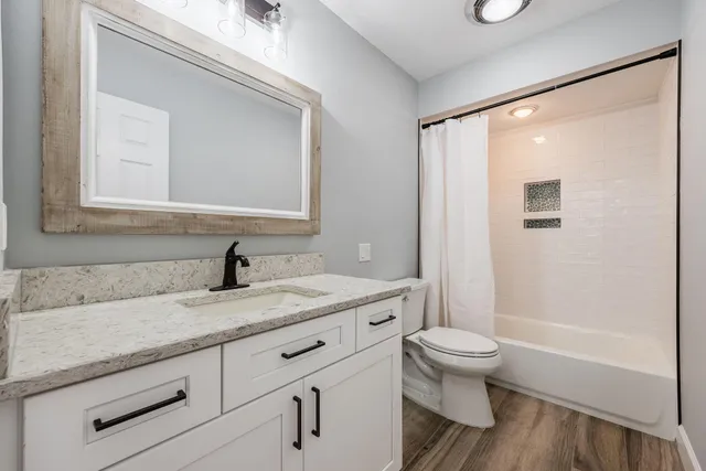 a bathroom with a granite countertop sink toilet and shower