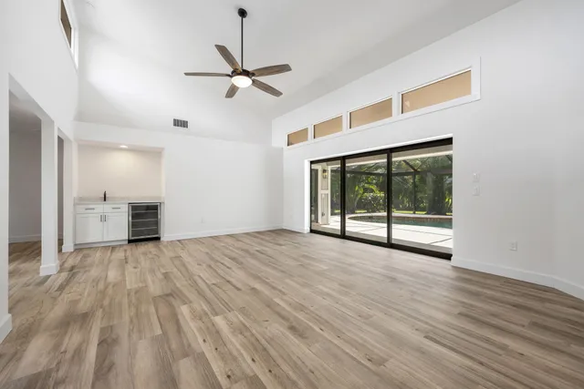 a view of an empty room with a window and wooden floor