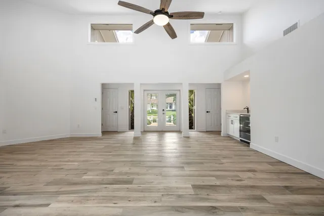 a view of an empty room with window and wooden floor