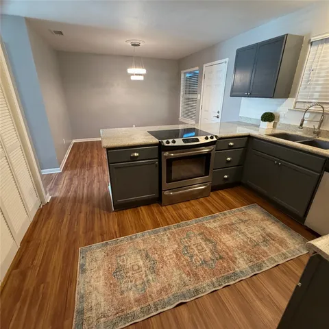 a kitchen with a sink and wooden floor