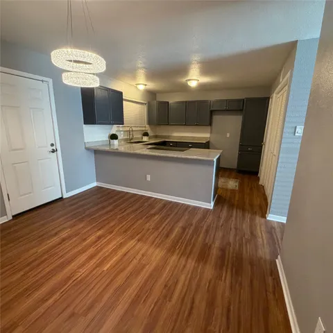 a room with kitchen island a wooden floor and a sink