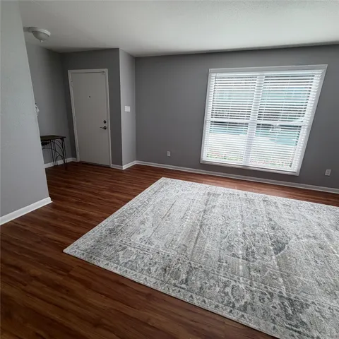 a view of a room with wooden floor and a window