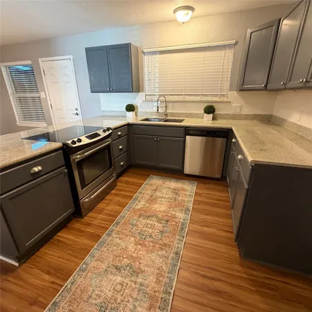 a kitchen with stainless steel appliances kitchen island granite countertop a sink stove and cabinets