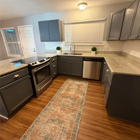 a kitchen with stainless steel appliances kitchen island granite countertop a sink stove and cabinets