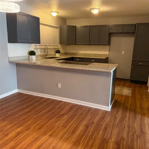 a kitchen with kitchen island wooden floors and stainless steel appliances