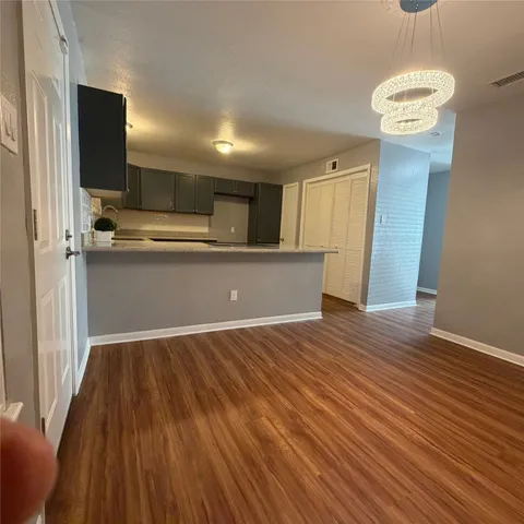 a view of kitchen with wooden floor and electronic appliances